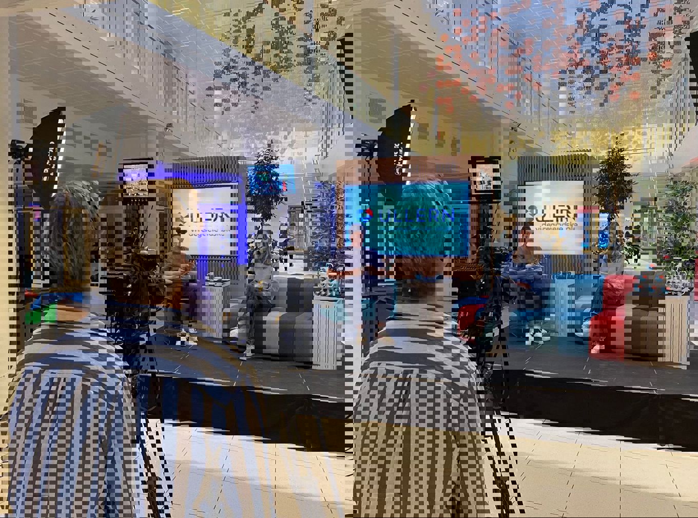 MK-elever produserer TV-sending på Åpen dag 2022. En fotograf, to programledere i studio-oppsett. MK-elever produserer TV-sending på Åpen dag 2022. En fotograf, to programledere i studio-oppsett.