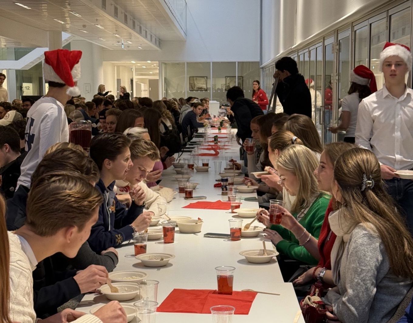 en gruppe mennesker som sitter ved et bord og spiser mat en gruppe mennesker som sitter ved et bord og spiser mat