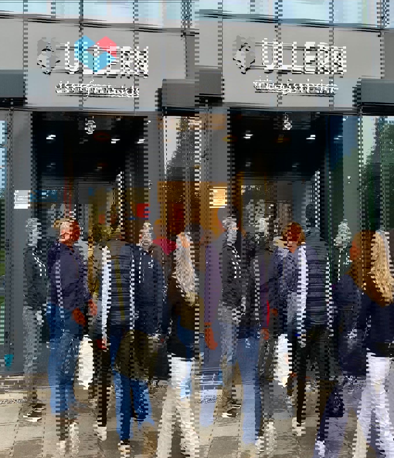 en gruppe mennesker som går utenfor en bygning en gruppe mennesker som går utenfor en bygning