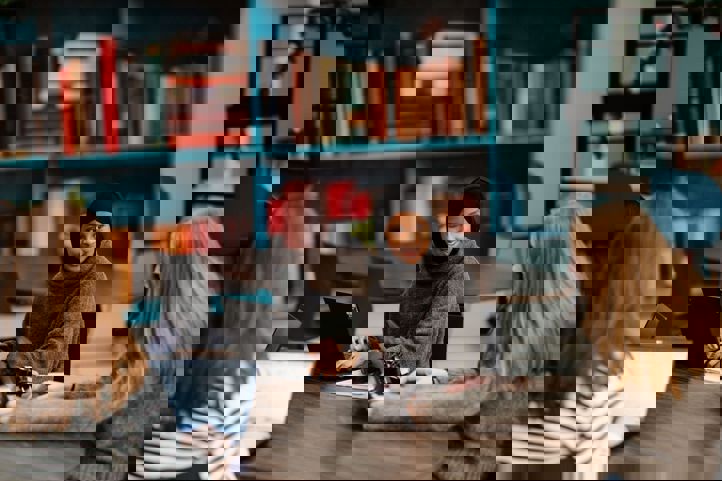 en gruppe personr som sitter ved et bord med bærbare datamaskiner