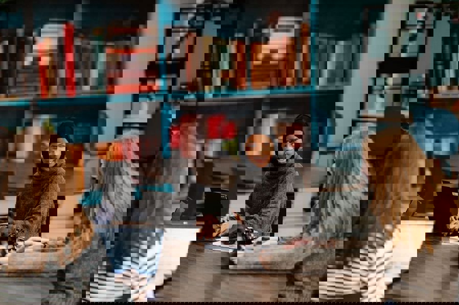 en gruppe personr som sitter ved et bord med bærbare datamaskiner