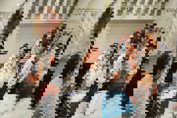 en gruppe mennesker som sitter ved et bord med bærbare datamaskiner