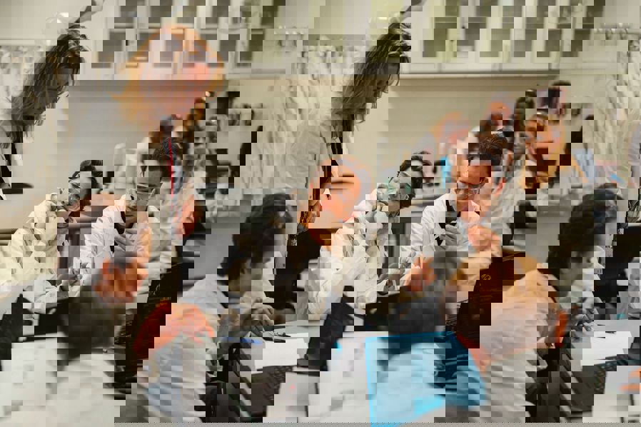 en gruppe mennesker som sitter ved et bord med bærbare datamaskiner