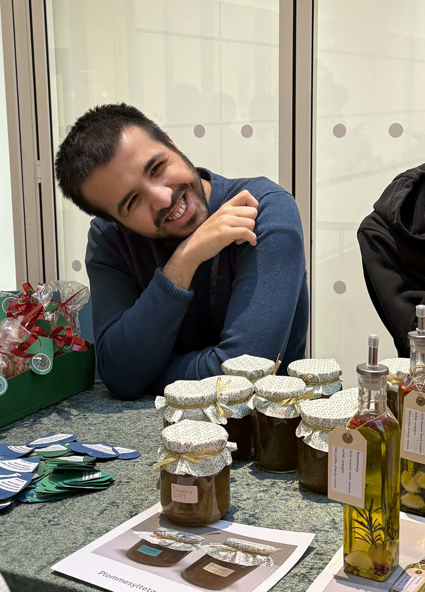 En person som sitter ved et bord med en gruppe krukker med mat