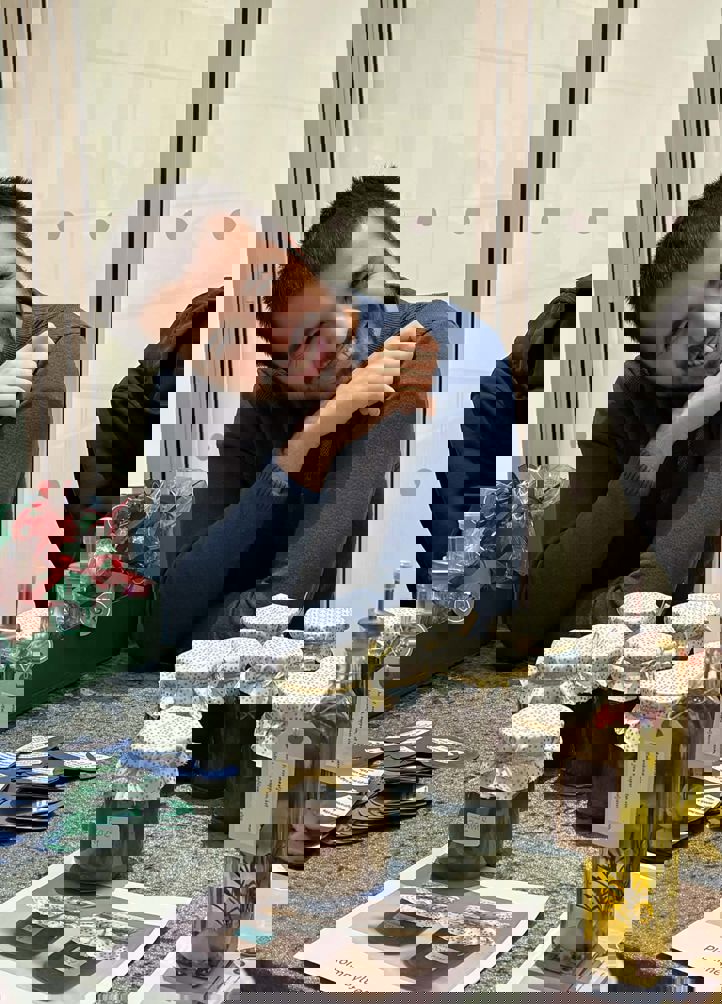 En person som sitter ved et bord med en gruppe krukker med mat