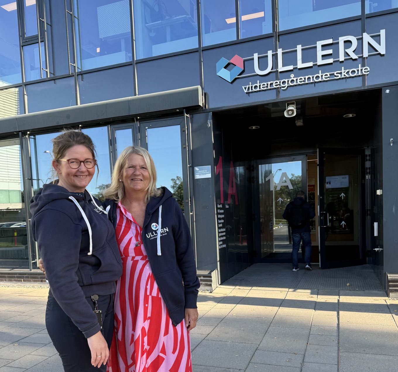 en person og en person som poserer for et bilde utenfor en bygning