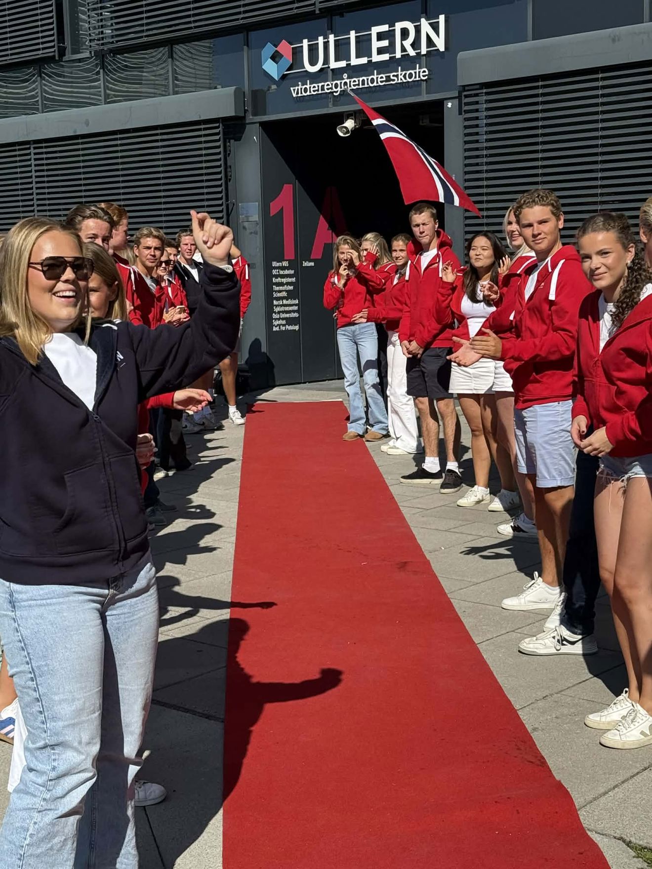 En gruppe mennesker som står på en rød løper