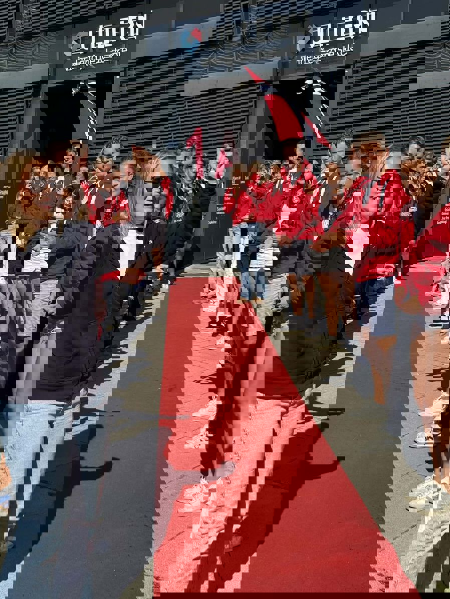 En gruppe mennesker som står på en rød løper