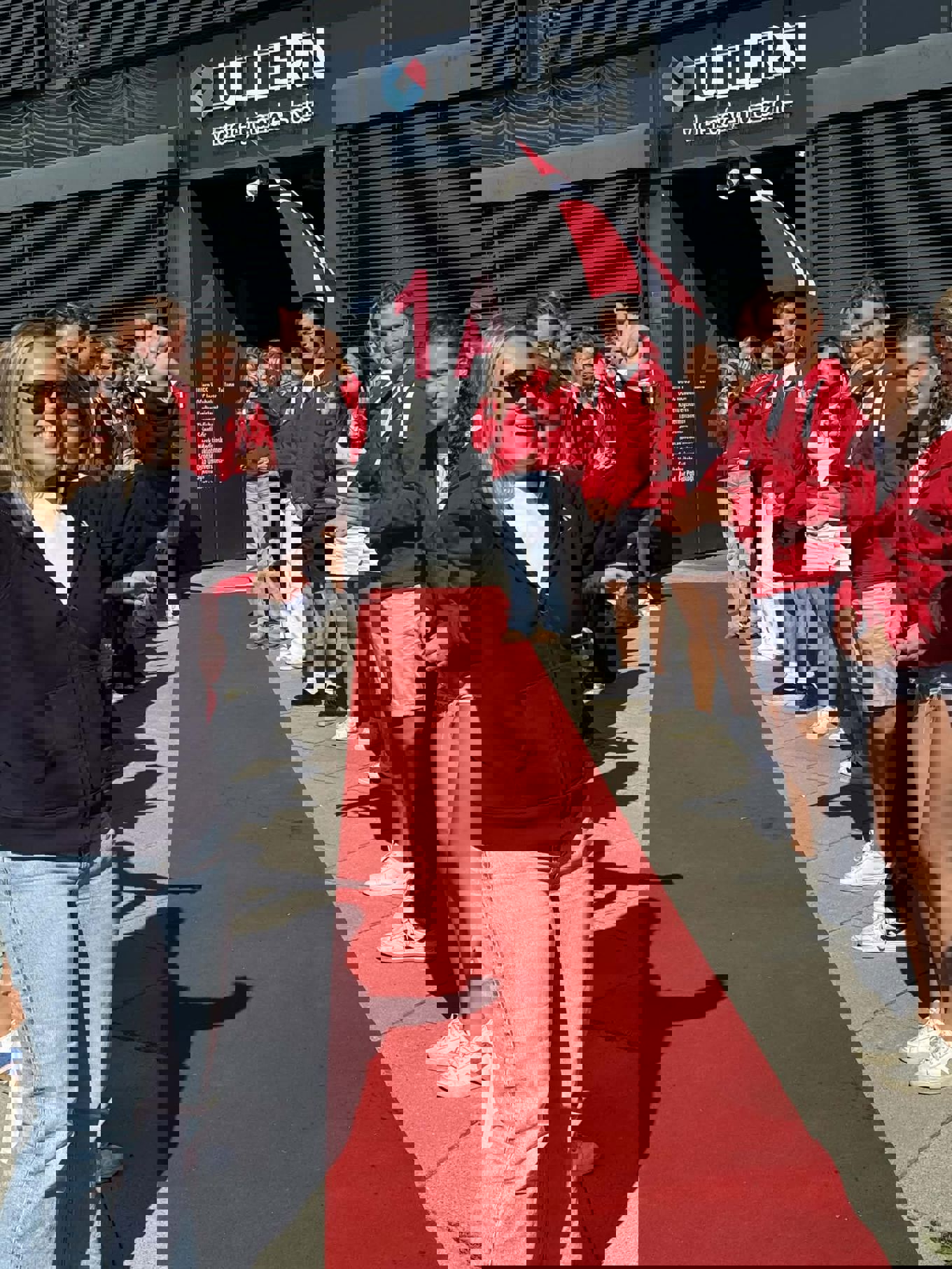 En gruppe mennesker som står på en rød løper En gruppe mennesker som står på en rød løper